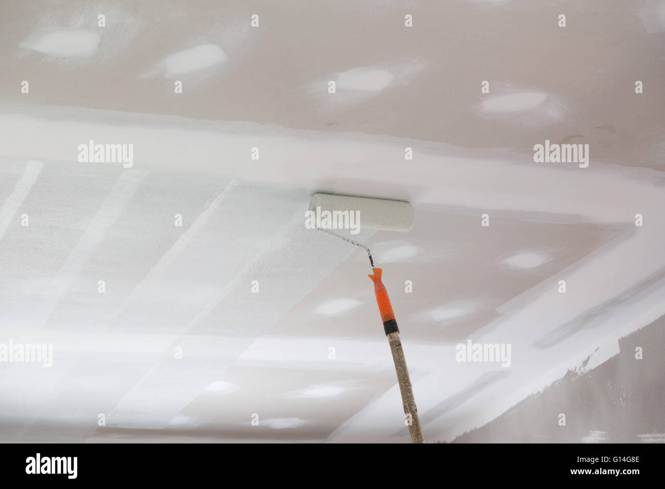 painting a gypsum plaster ceiling with painting roller Stock Photo Alamy