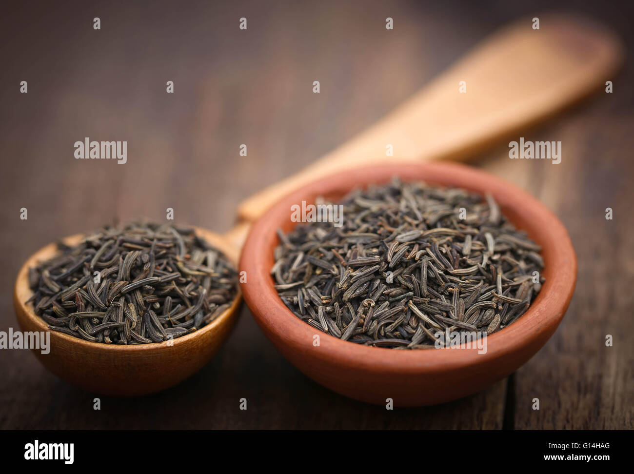 Caraway seeds in a wooden spoon and bowl Stock Photo