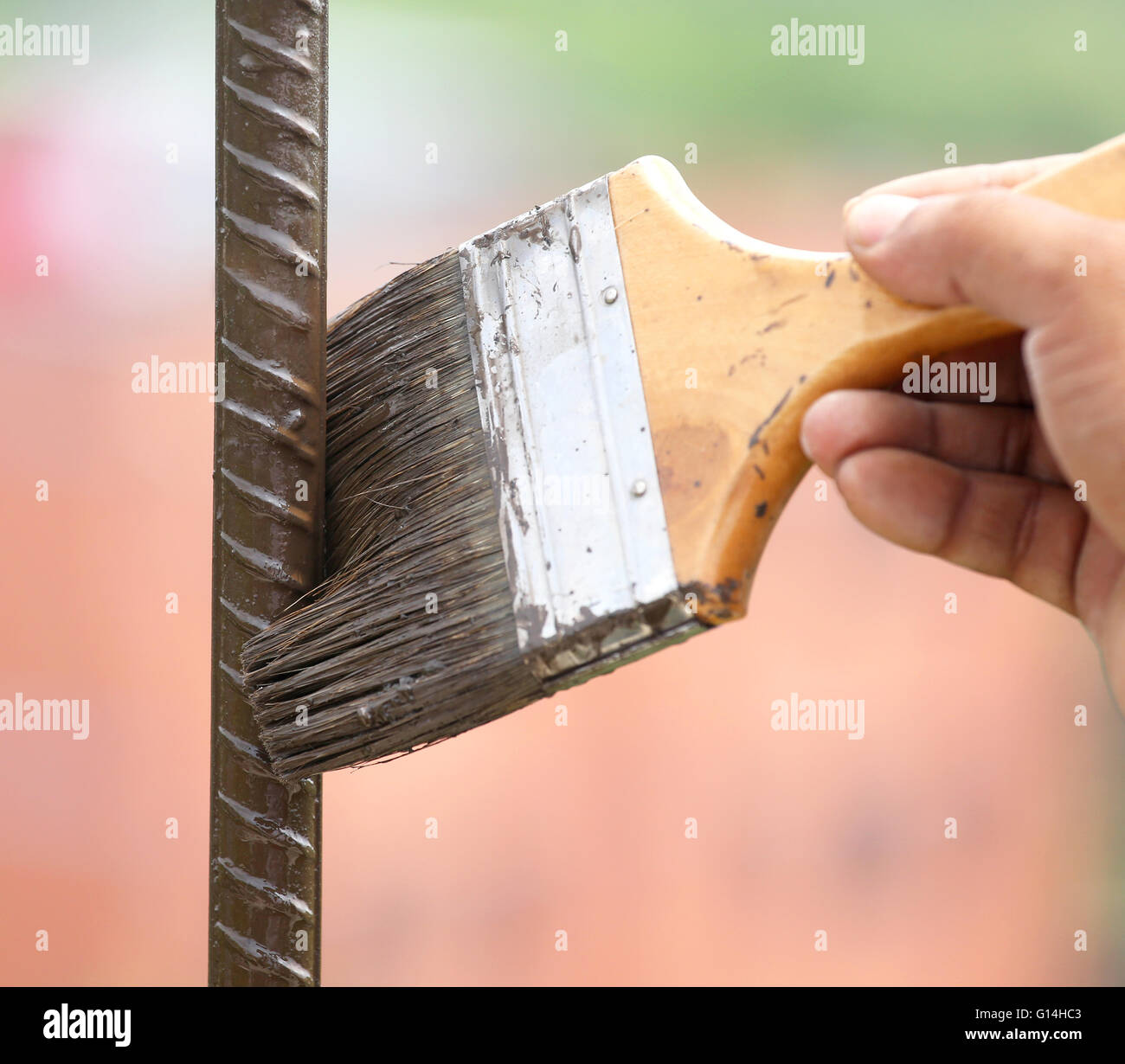 Painting an iron rod outdoor with a brush Stock Photo
