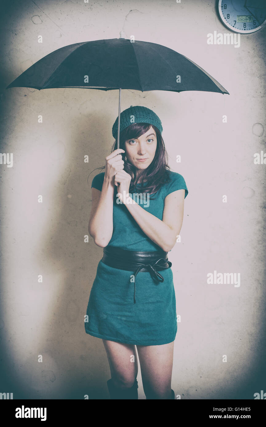 Young woman in 70s style portrait with umbrella old vintage image effect Stock Photo