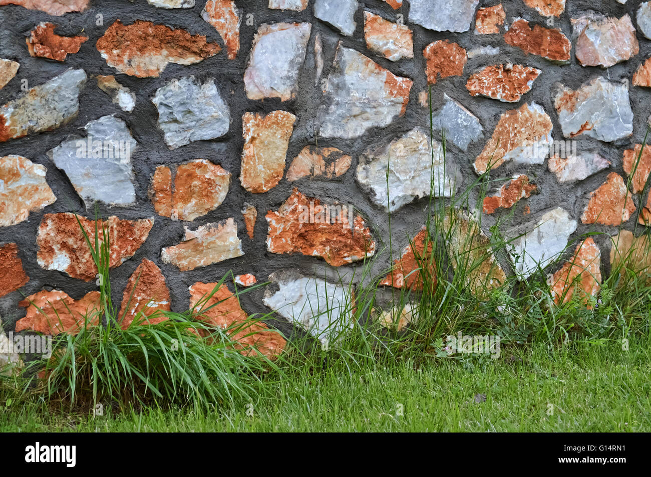 Detail of stonewall and green grass for background Stock Photo - Alamy