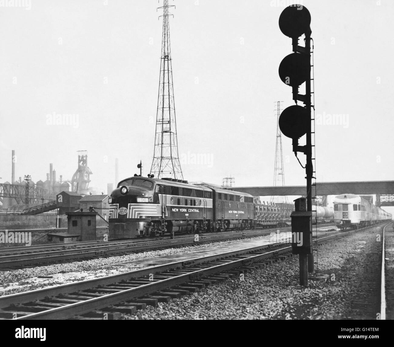 Historic image of a New York Central freight train, believed to be an EMD E8, as it passes the steel mills at Indiana Harbor, Indiana, on the New York Central's Buffalo-Chicago line. Stock Photo