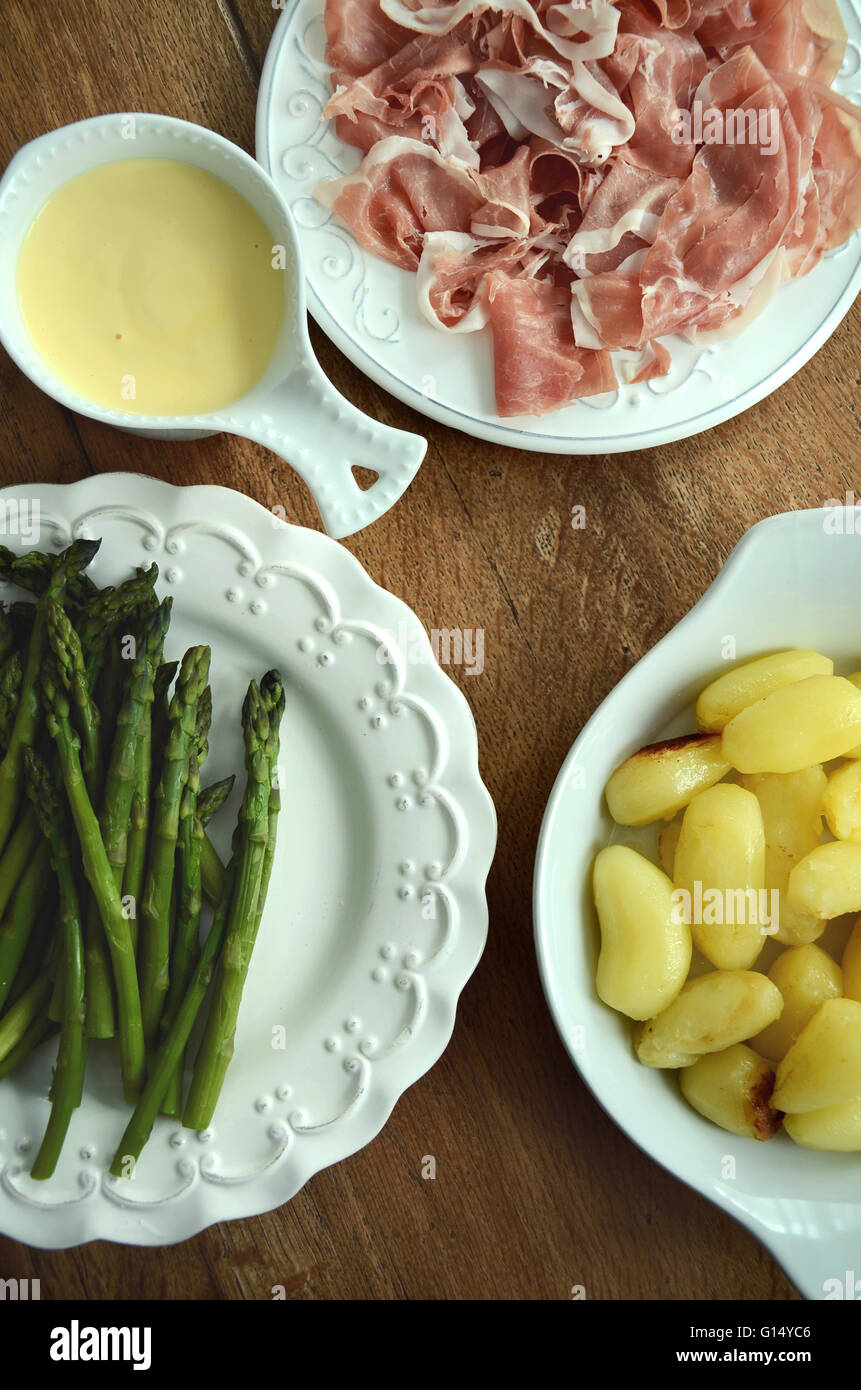 Green asparagus with prosciutto and new potatoes served with sauce