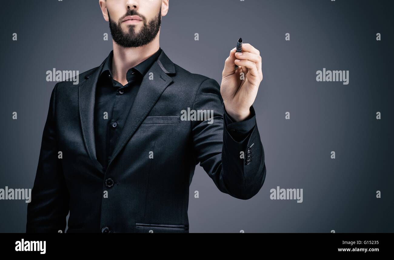 Young businessman holding a pen in his hand Stock Photo - Alamy