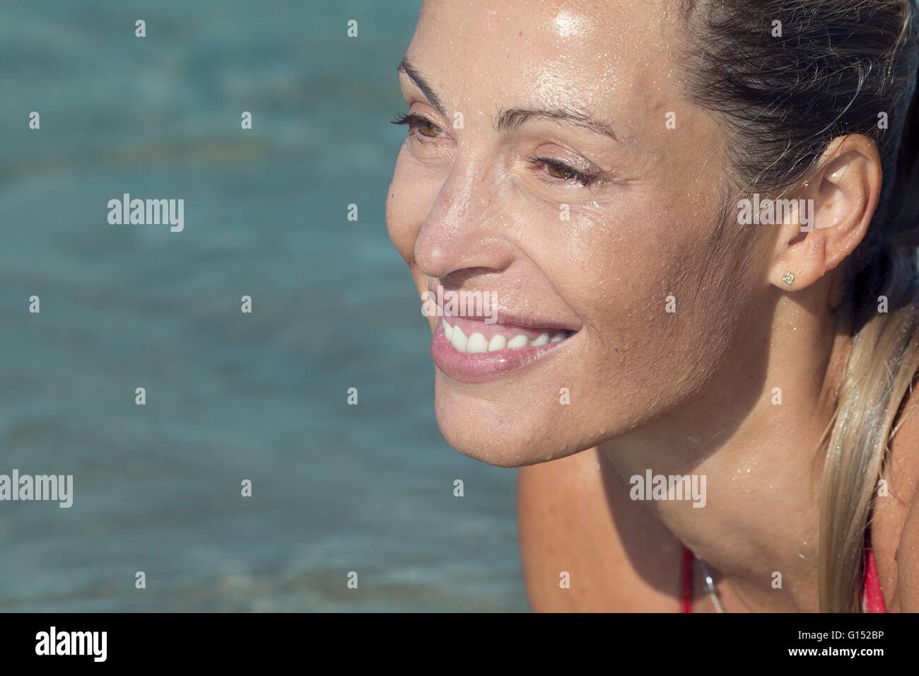Close-up of profil smiling blond woman lying in water Stock Photo - Alamy