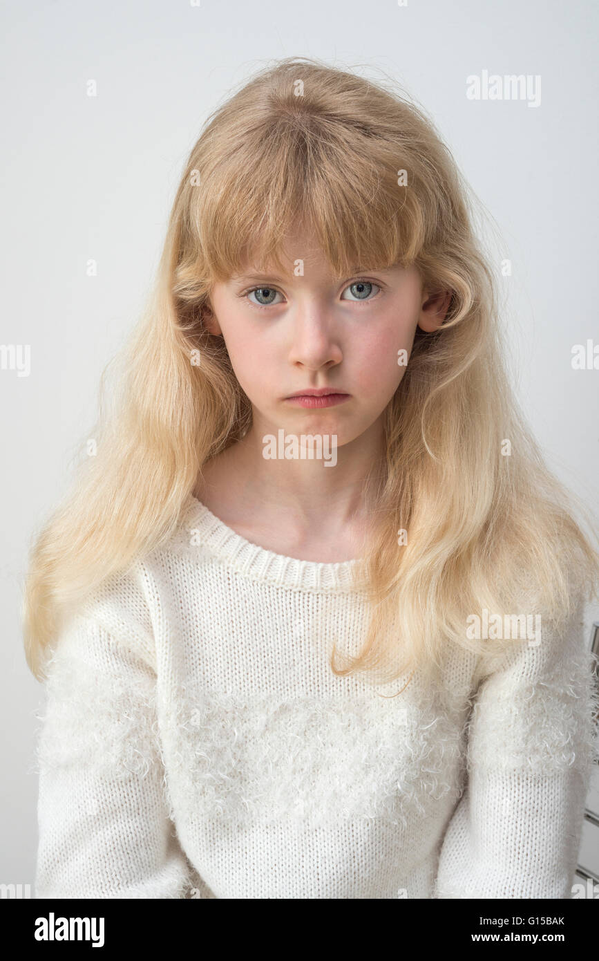 young eleven year old girl sad unhappy gloomy worried pensive thinking Stock Photo