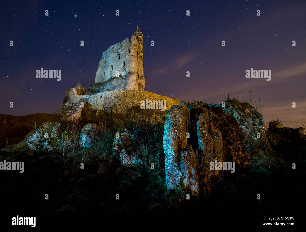 View of rocks and Mirow Castle ruins illuminated at night, Polish Jura, Poland, Europe Stock Photo