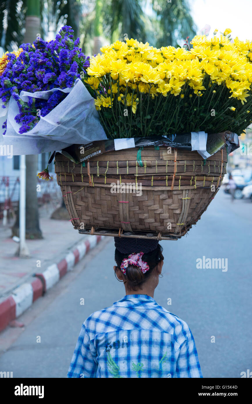 Woman carrying large flower basket on her head, Yangon (Rangoon), Myanmar (Burma), Asia Stock Photo
