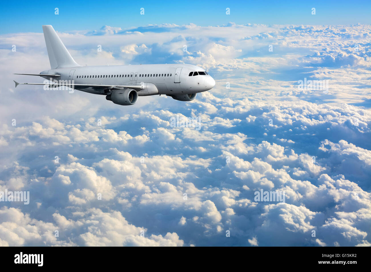 Commercial passenger plane flying above clouds Stock Photo