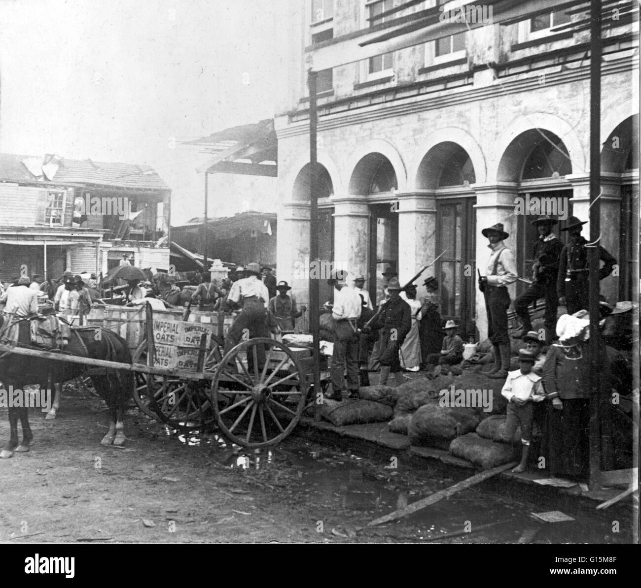 Horse-drawn carts for food delivery, protected by armed guards, outside the Commissary in Galveston, Texas. The Hurricane of 1900 made landfall on the city of Galveston, Texas, on September 8, 1900. It had estimated winds of 145 miles per hour at landfall Stock Photo