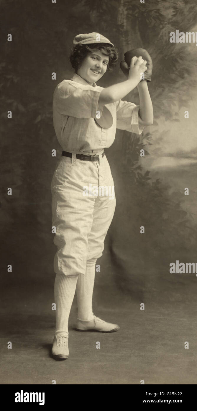 Woman in pitcher stance wearing a baseball uniform, studio shot, 1913