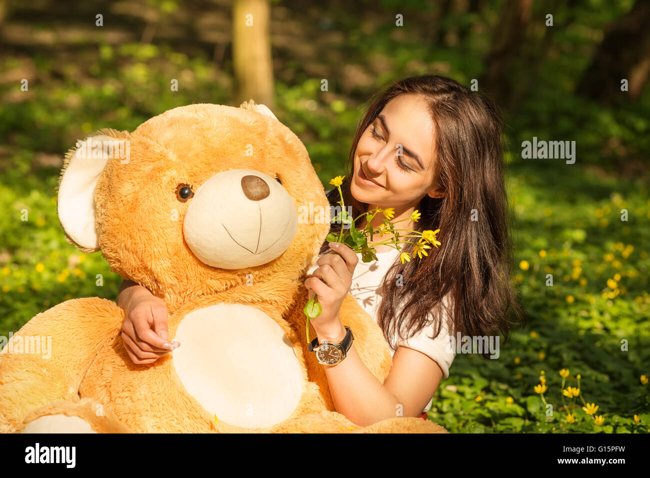girl with teddy bear sitting on grass in forest Stock Photo - Alamy