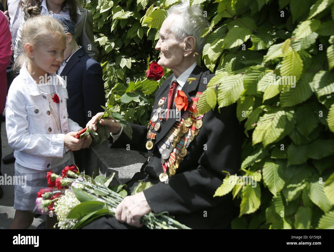 The girl gives flowers to the Veteran of World War II near the monument ...