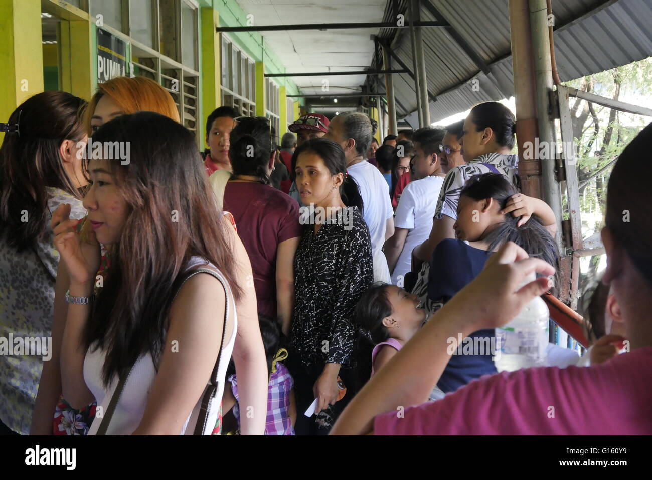Mandaluyong, Philippines. 09th May, 2016. A frustrated and tired lady getting through this crowd. Everyone waiting for the VCM to work. © George Buid/Pacific Press/Alamy Live News Stock Photo