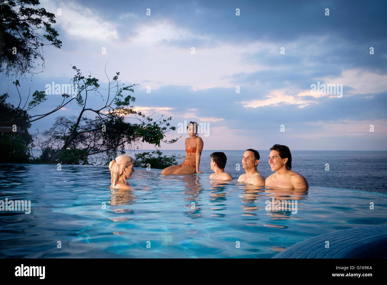Five young people about to start party in infnity swimming pool in Puerto Vallarta, Mexico Stock Photo