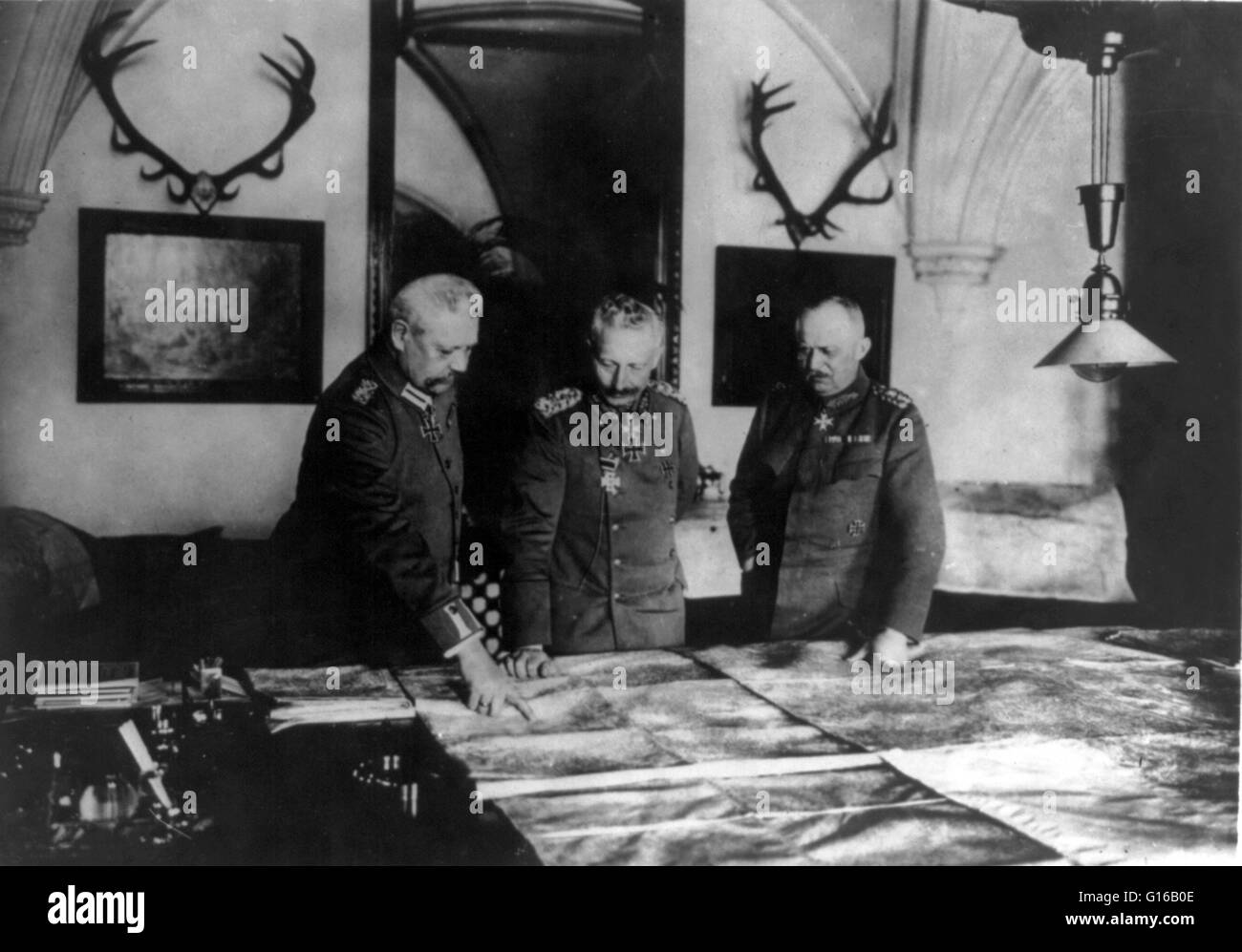 Photograph shows General Paul von Hindenburg, Kaiser Wilhelm II, and General Erich Ludendorff standing at a table, examining large maps, circa 1914-18. Wilhelm II (January 27, 1859 - June 4, 1941) was the last German Kaiser and King of Prussia, ruling the Stock Photo