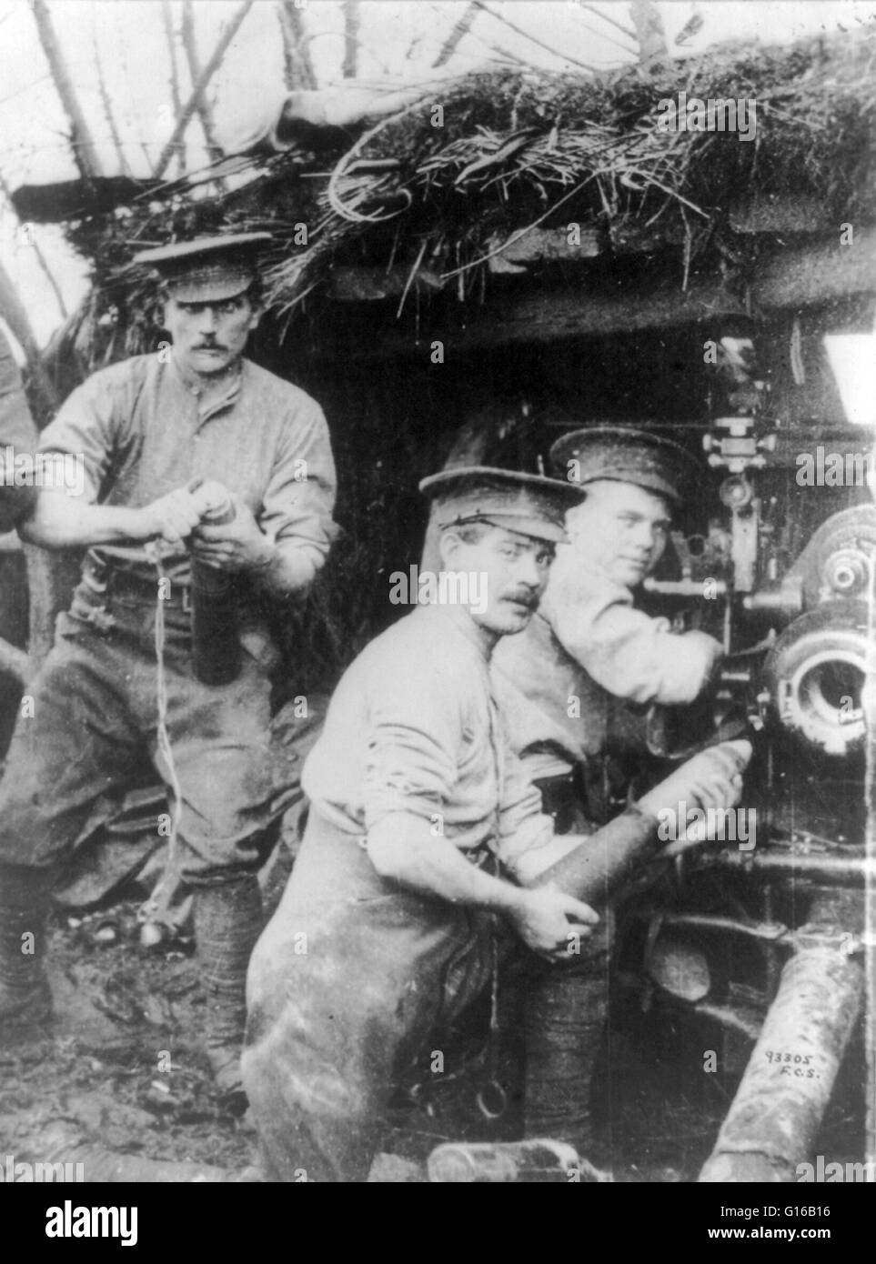 British soldiers loading a cannon or howitzer in a camouflaged bunker, 1915. The onset of trench warfare after the first few months of First World War greatly increased the demand for howitzers that gave a steep angle of descent, which were better suited Stock Photo