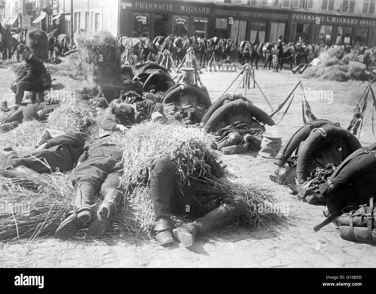 French soldiers resting on the ground in a plaza in front of a pharmacy in France during World War I. In January 1914, the French Army had 47 divisions, composed of 777,000 French soldiers and 47,000 colonial troops. Another 2.9 million men were mobilized Stock Photo