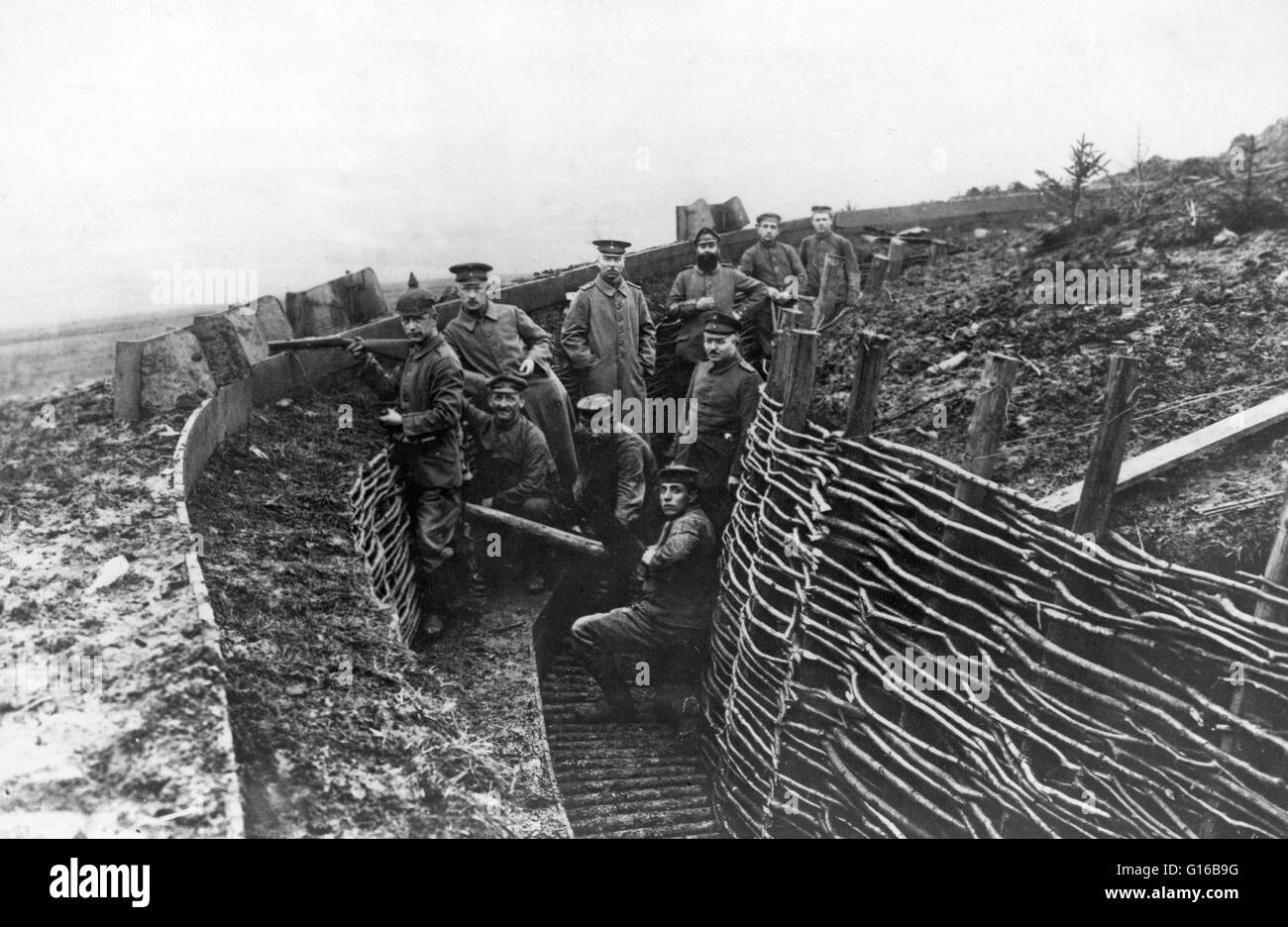 German military personel in a trench. Trench warfare is a form of land warfare using occupied fighting lines consisting largely of trenches, in which troops are significantly protected from the enemy's small arms fire and are substantially sheltered from Stock Photo