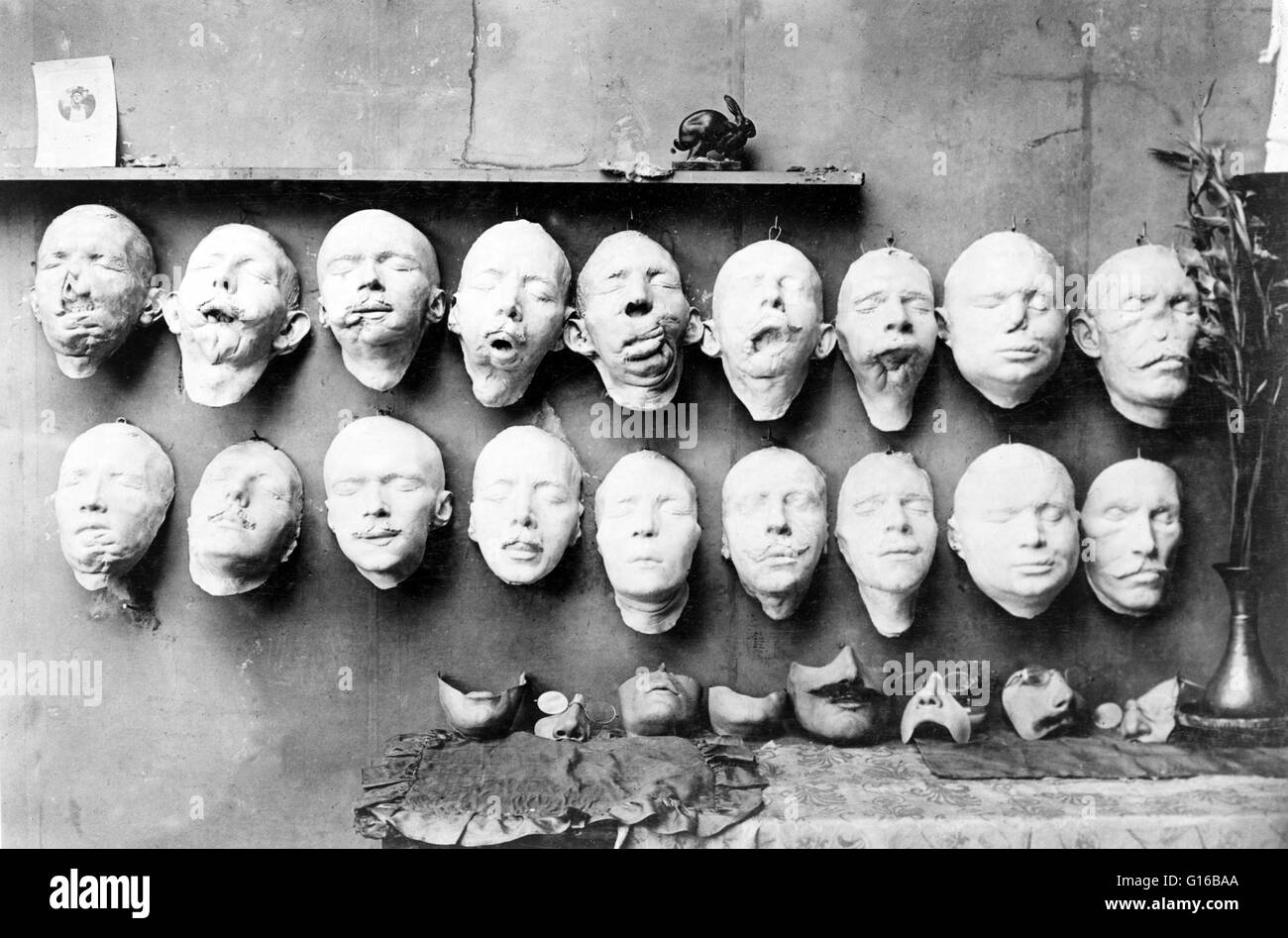 Casts taken from the soldiers' mutilated faces; the lower row shows the faces which Mrs. Ladd modeled on the foundation of the life mask with help of photographs taken before the wound was received. On the table are some of the final masks made to fit ove Stock Photo