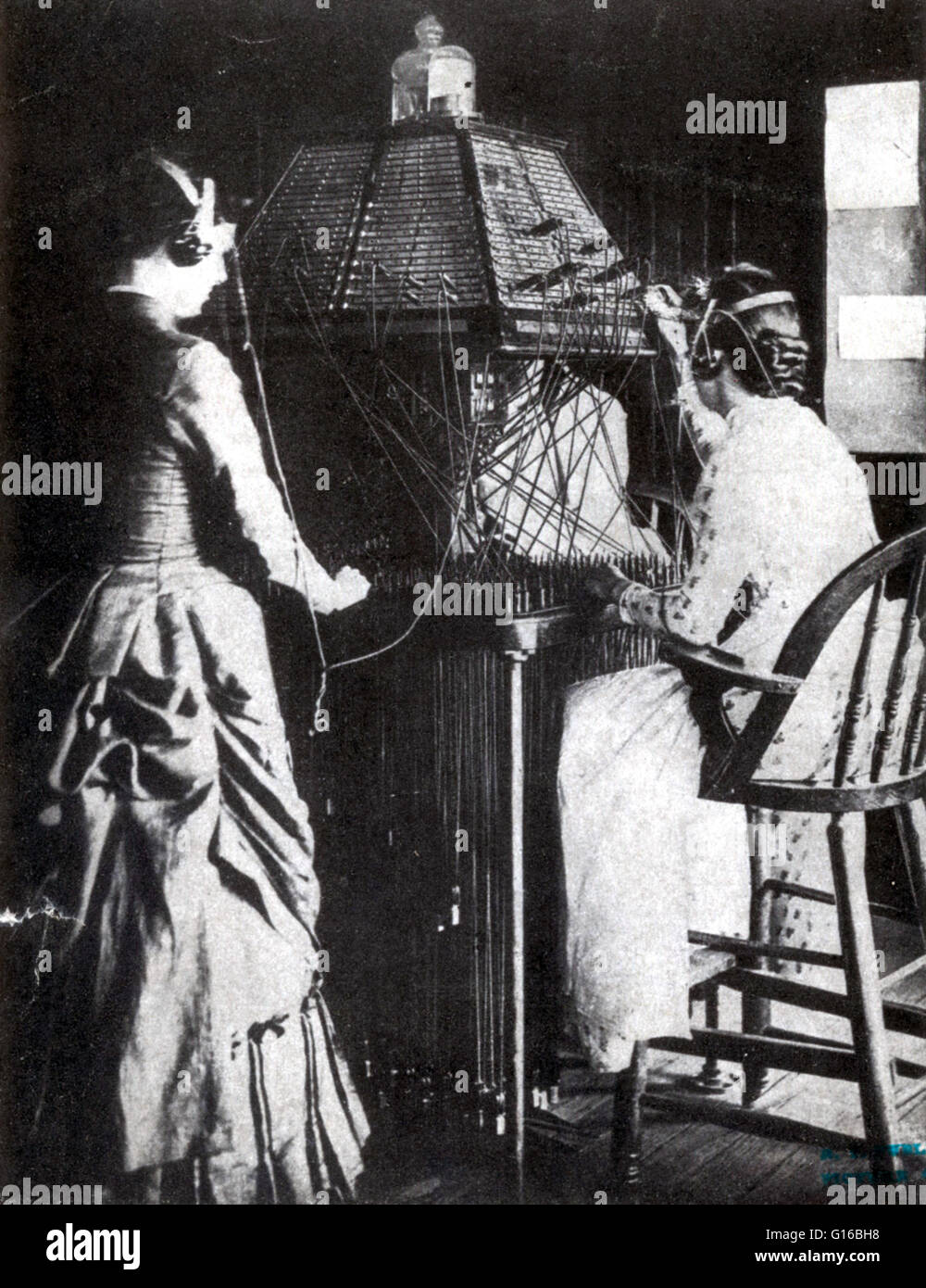 Women operators plugging into a lampshade switchboard in Richmond, Virginia in 1884. Early switchboards in large cities usually were mounted floor to ceiling in order to allow the operators to reach all the lines in the exchange. The operators were boys w Stock Photo