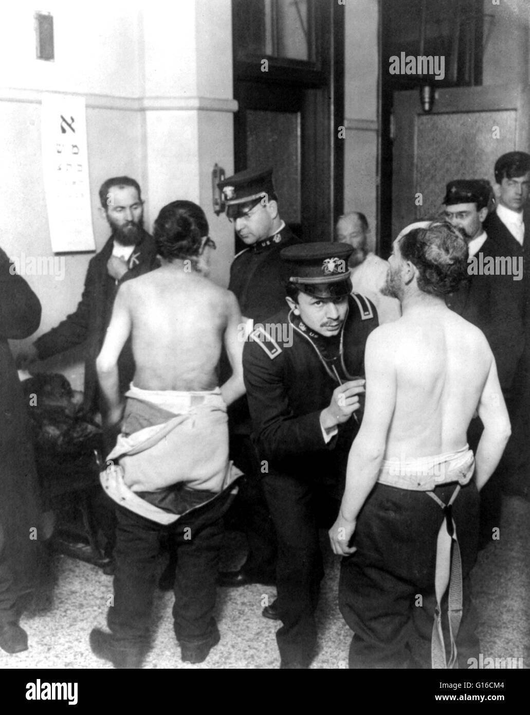 Entitled: 'Physicians examining a group of Jewish immigrants, 1907.' Photograph shows immigrants gathered in small room, two with shirts off being examined by physicians; eye chart written in Hebrew hangs on wall. In the 35 years before Ellis Island opene Stock Photo