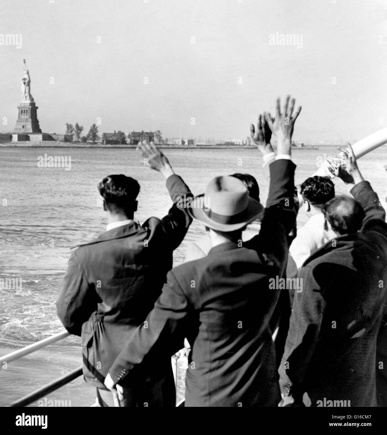 Entitled: 'Part of a group of 171 aliens illegally in the country wave goodbye to the Statue of Liberty from the Coast Guard cutter that took them from Ellis Island to the Home Lines ship Argentina in Hoboken for deportation.' In the 35 years before Ellis Stock Photo