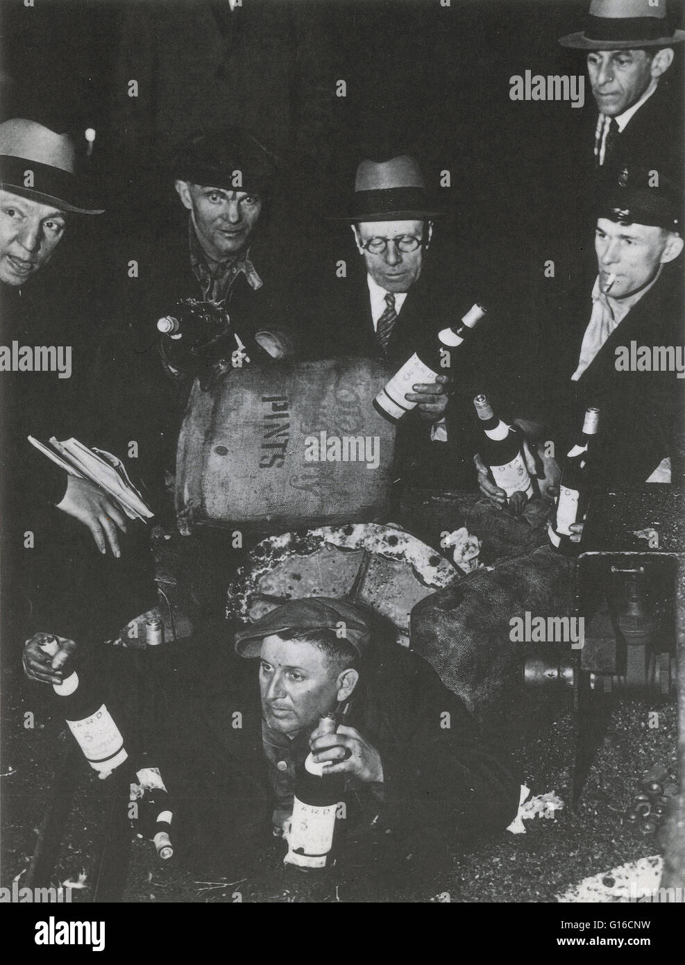 Federal agents uncovering bottles of alcohol during a raid on a speakeasy in New York City, 1932. Prohibition in the United States was a nationwide Constitutional ban on the sale, production, importation, and transportation of alcoholic beverages that rem Stock Photo