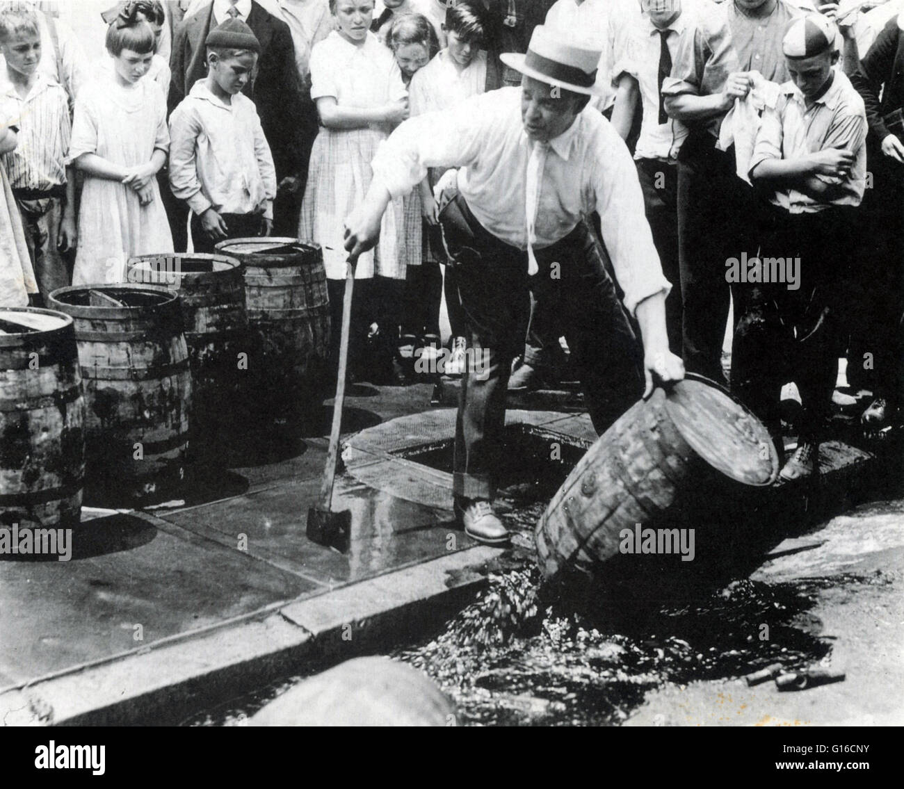 An Revenuer dumping kegs of bootleg liquor into the sewer during