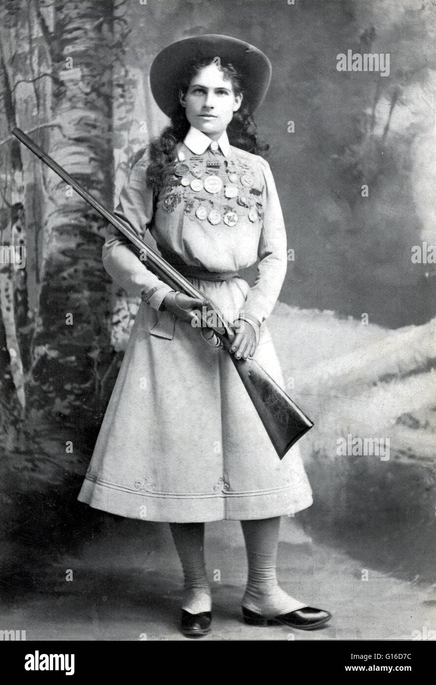 Sharpshooter Annie Oakley, holding rifle, with many medals pinned across  the top of her dress photographed by Richard Kyle Fox, 1899. Annie Oakley  (August 13, 1860 - November 3, 1926) born Phoebe
