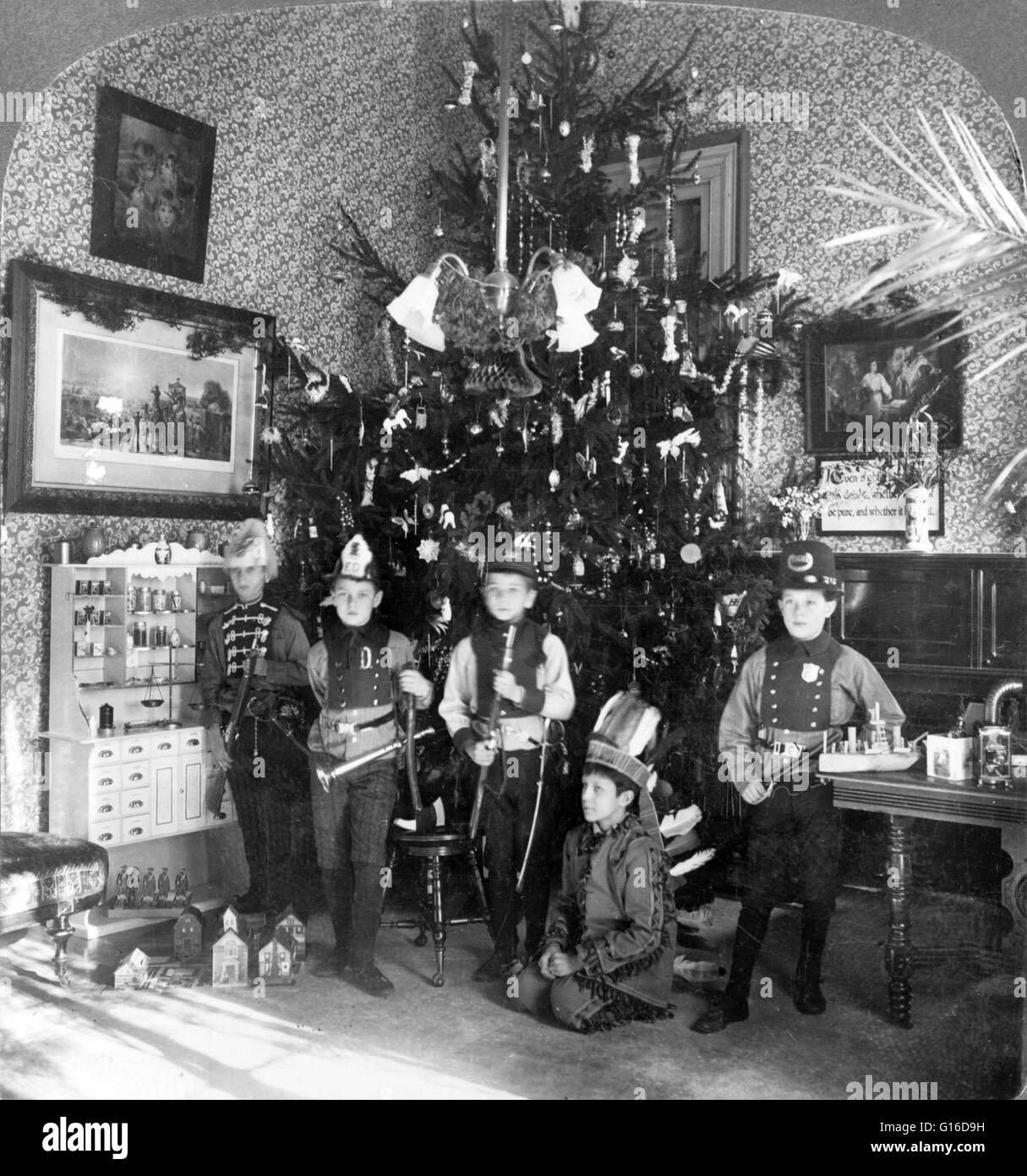 Entitled: 'Lyndhurst - A happy Christmas at Woody Crest, December, 1905' showing five boys in costumes, with toys, in front of Christmas tree, Lyndhurst school, Tarrytown, New york. A Christmas tree is a decorated tree, usually an evergreen conifer such a Stock Photo
