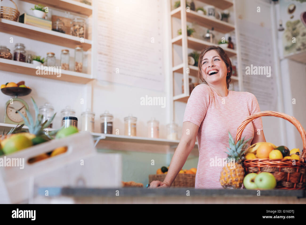 Portrait of beautiful young woman standing at a juice bar counter and
