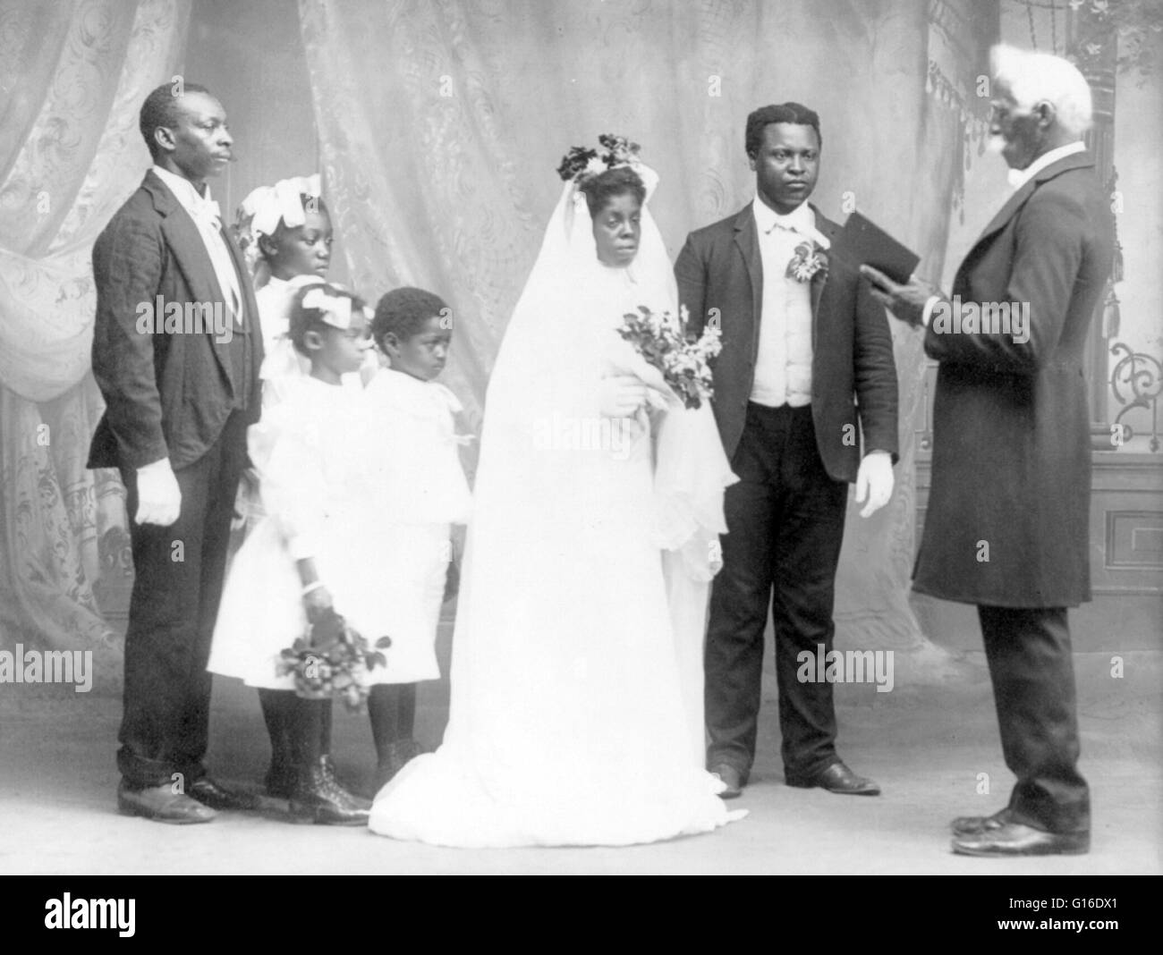 Entitled: 'She was led to the Altar' shows an African-American wedding showing bride and groom, preacher, three children and one other man. Wedding traditions and customs vary greatly between cultures, ethnic groups, religions, countries, and social class Stock Photo