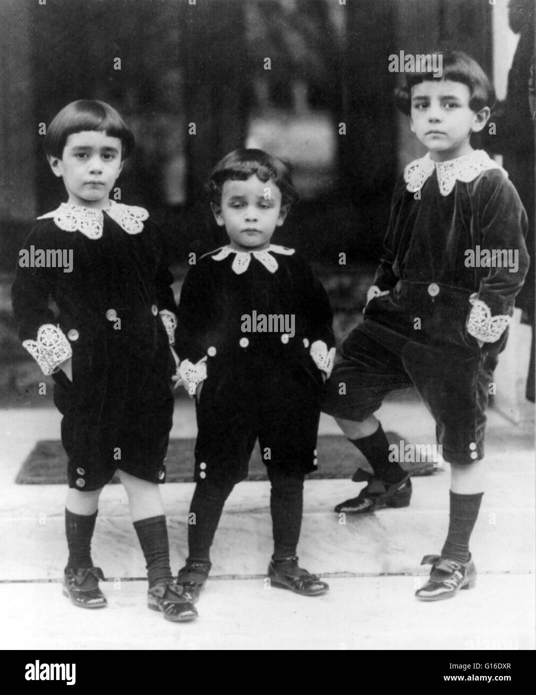 Entitled: 'Children wearing velvet suits inspired by Little Lord Fauntleroy style'. The classic Fauntleroy suit was a velvet cut-away jacket and matching knee pants worn with a fancy blouse with a large lace or ruffled collar. The Fauntleroy suit, so well Stock Photo