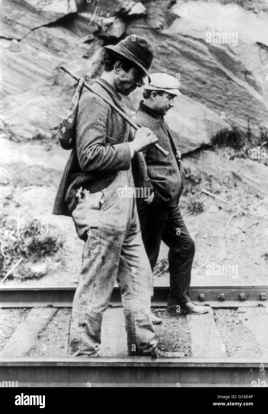 Entitled: 'Two hobos walking along railroad tracks, after being put off a train.' A hobo is someone who wanders from place to place without a permanent home or a means of livelihood. With the end of the American Civil War in the 1860s, many discharged vet Stock Photo
