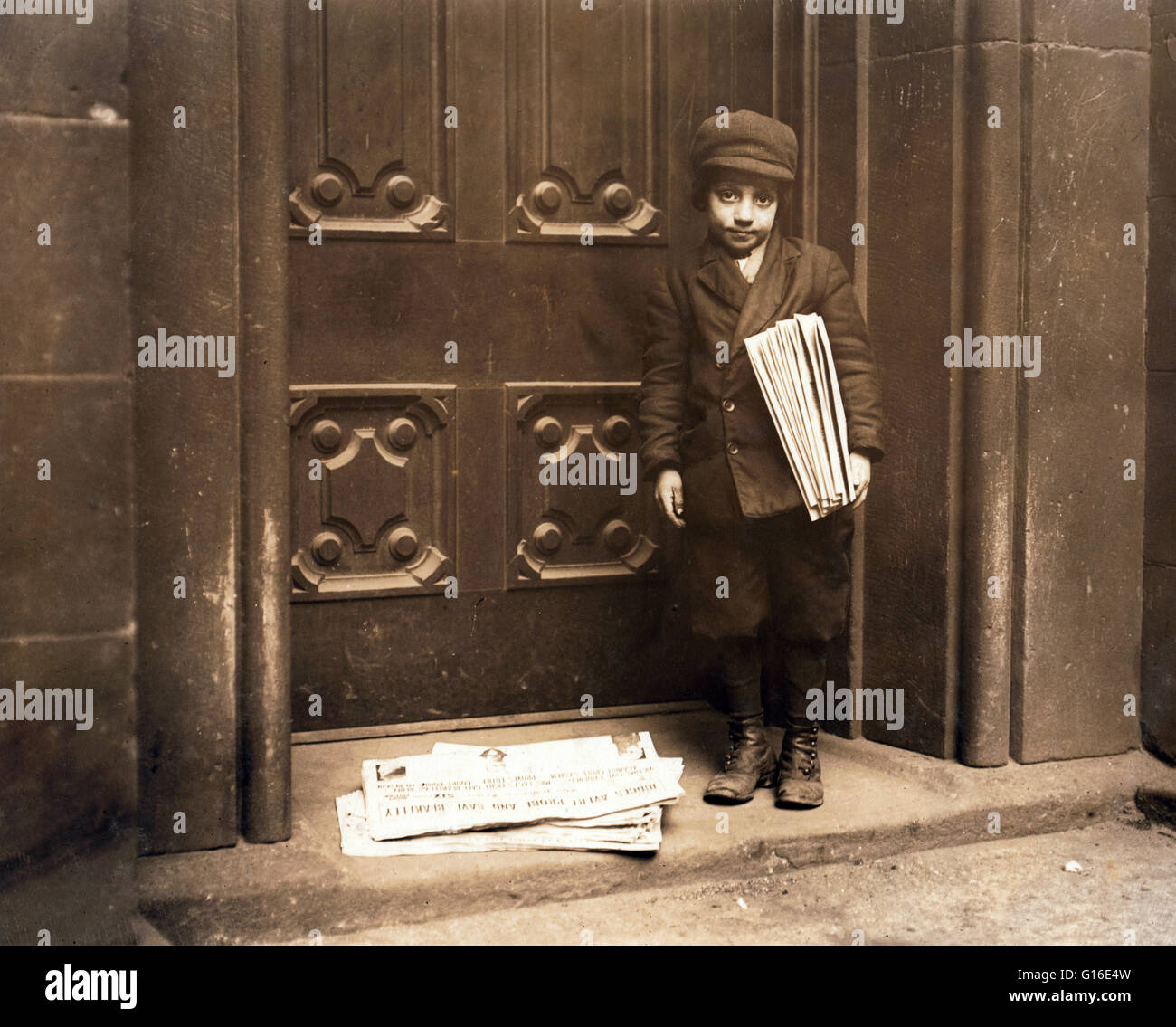 Entitled: 'Newsboy, 1913.' Date based on captions for neighboring numbers. 'Pittsburg' may be in text at top of newspaper on ground, but neighboring newsboy photos taken in New York. Headline appears to be 'Judges avert probe and Save Blakeley.' The posit Stock Photo