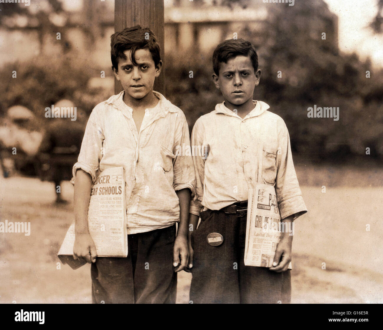 Entitled: 'Eddie and Carmine Zizza, twelve year old twins who make $1.50 a day. They belong to a family of 13 children many of them newsboys. Location: Newark, New Jersey. August 1st, 1924.' The position of paperboy occupies a prominent place in many coun Stock Photo