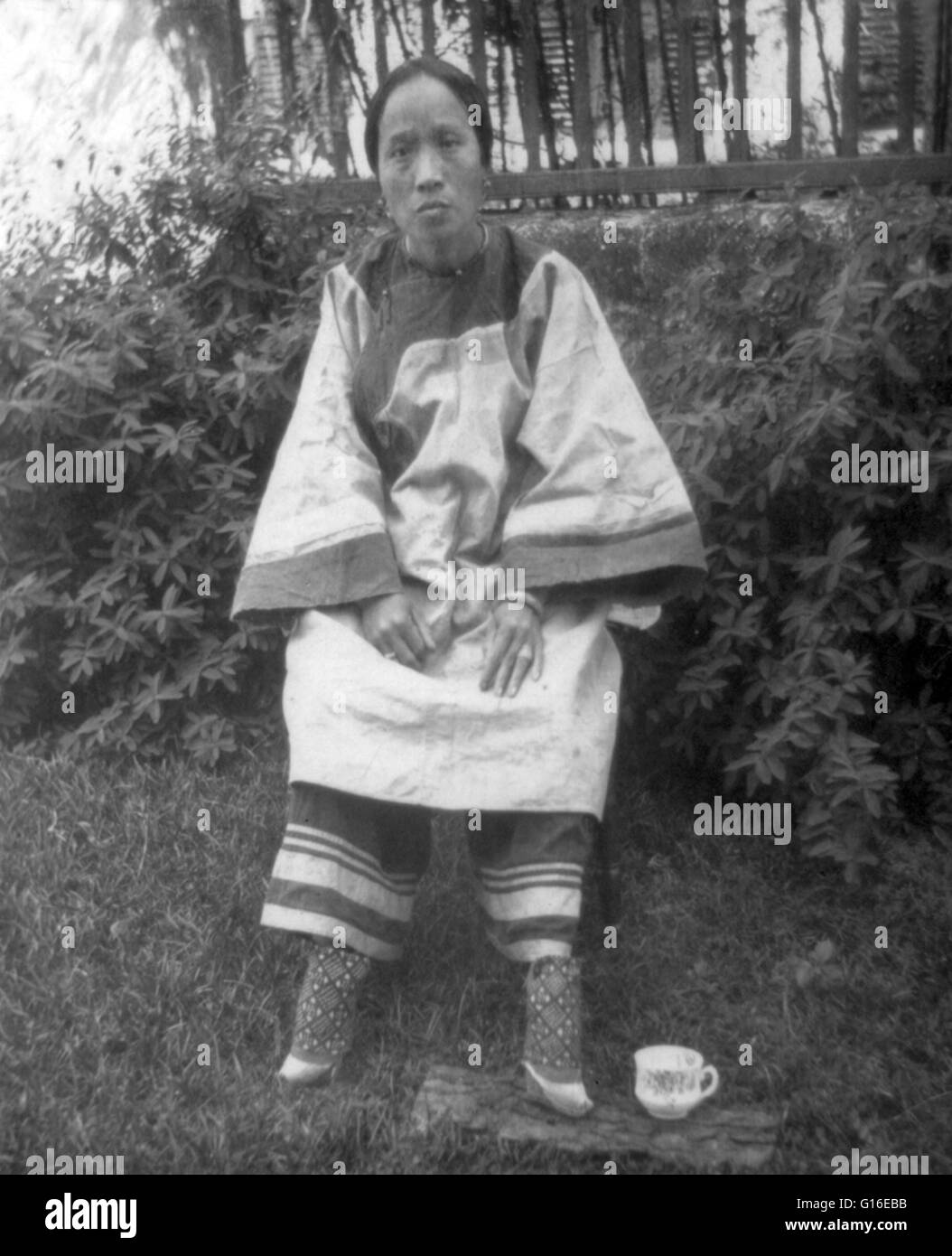 Entitled: 'A small-footed Chinese lady, 1905.' Foot binding (also known as 'Lotus feet') was the custom of applying painfully tight binding to the feet of young girls to prevent further growth. The practice possibly originated among upper-class court danc Stock Photo