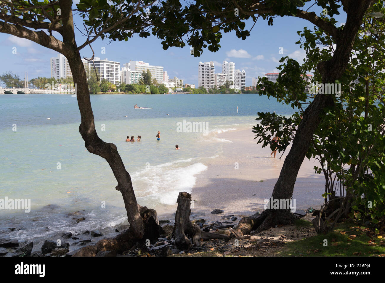 San Juan, Puerto Rico.  Local residents on the edge of Condado beach overlooking the luxury hotels of the beach. Stock Photo