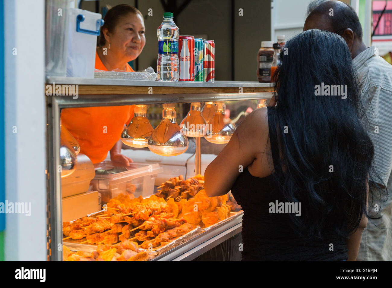 An owner of a food stall welcomes tourists with variety of Puerto Rican fried snacks in Old San Juan San Juan, Puerto Rico. Stock Photo