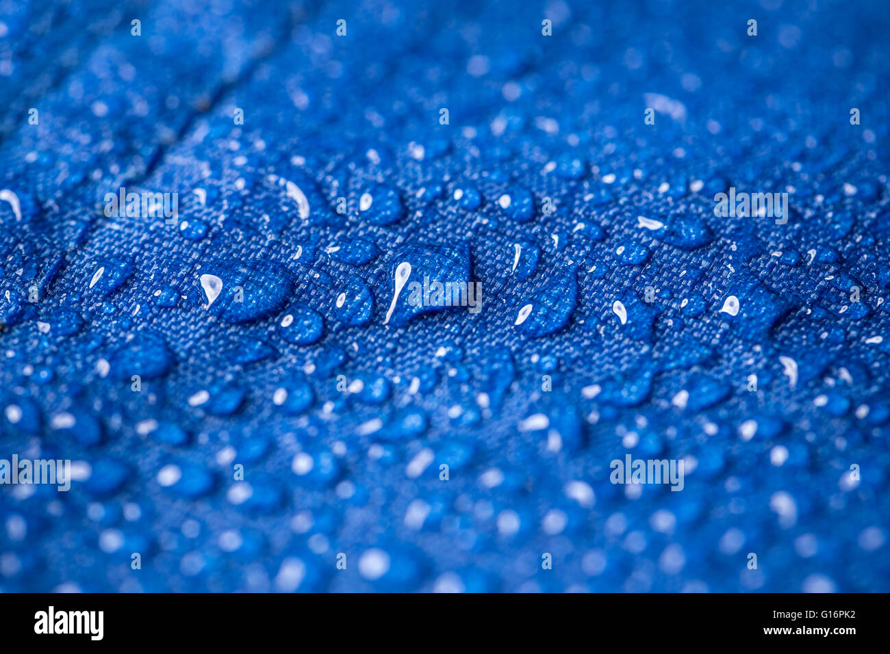 Rain water droplets on blue fiber waterproof fabric Stock Photo
