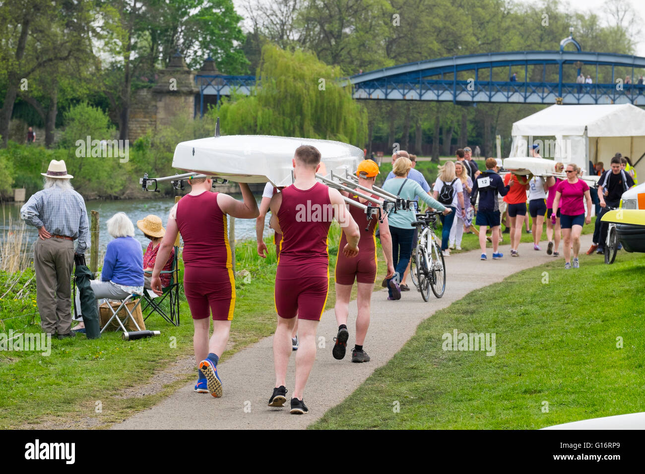 Rowers competing in Shrewsbury Regatta carry their boats alongside the