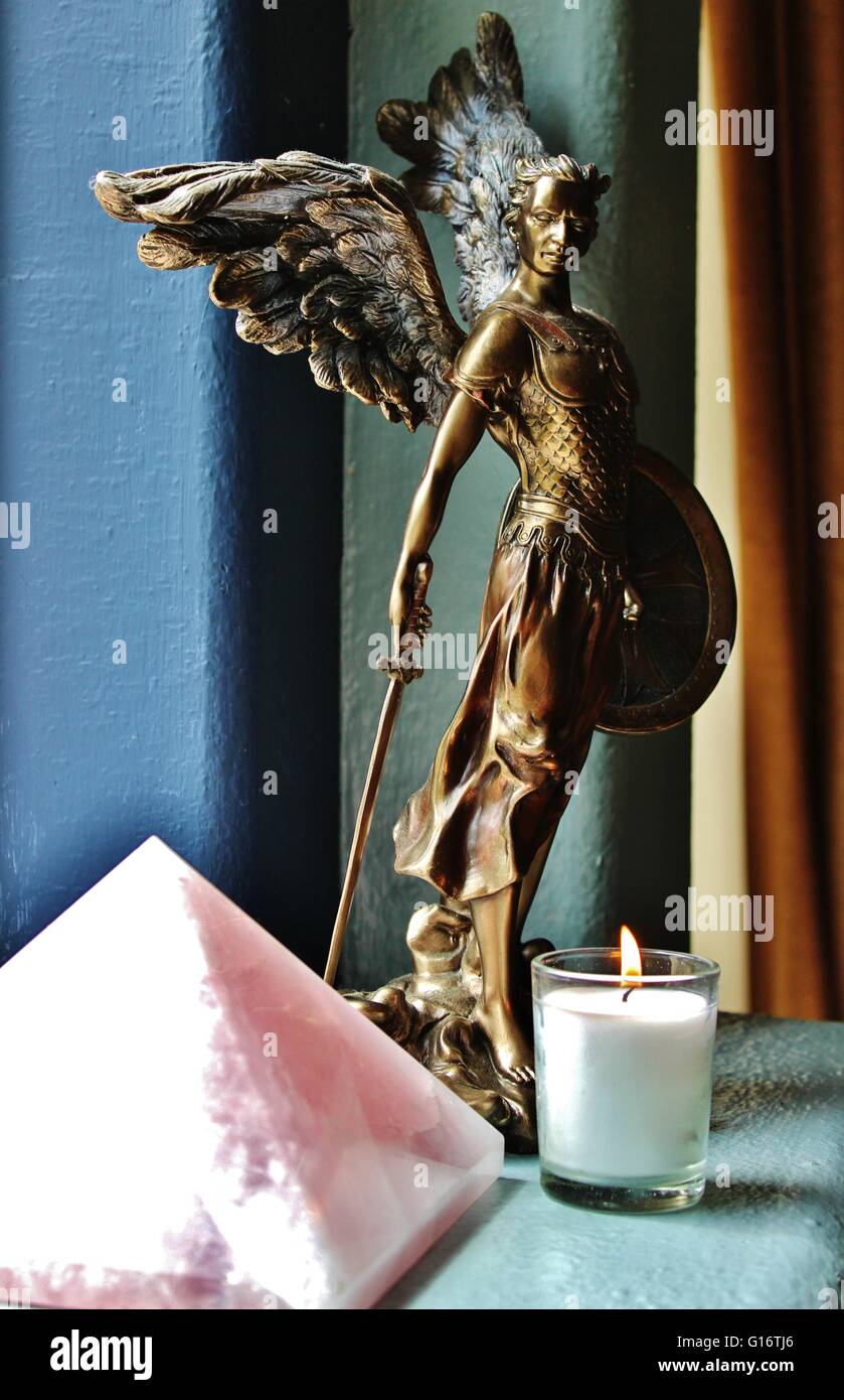 archangel michael statue pink crystal quartz pyramid white candle flame Stock Photo
