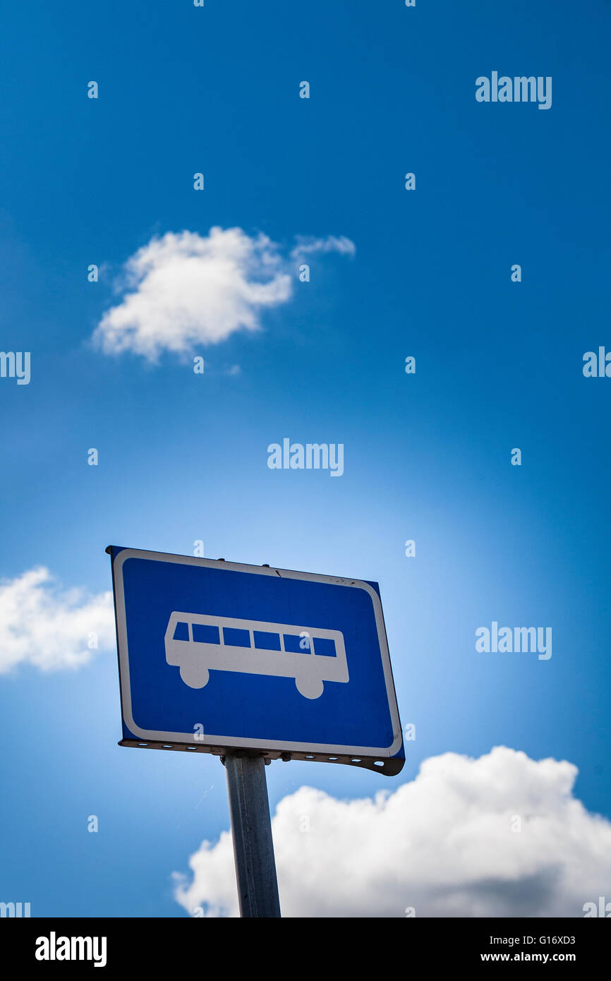 Bus sign post against blue sky with fluffy clouds  Model Release: No.  Property Release: No. Stock Photo