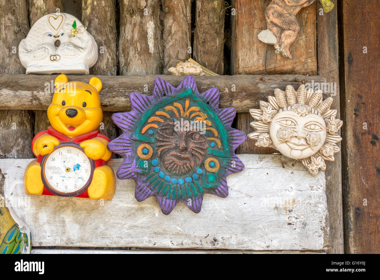 A Winnie The Pooh Cartoon Clock Hanging On A Mexican Wall With Mayan Wall Plaques Stock Photo