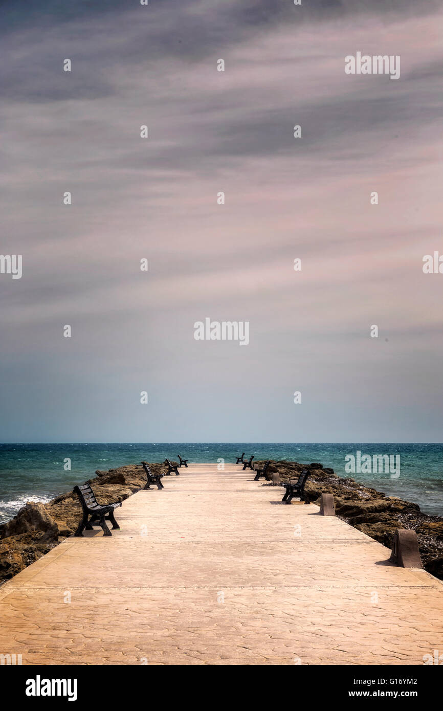 a jetty with benches into the sea Stock Photo