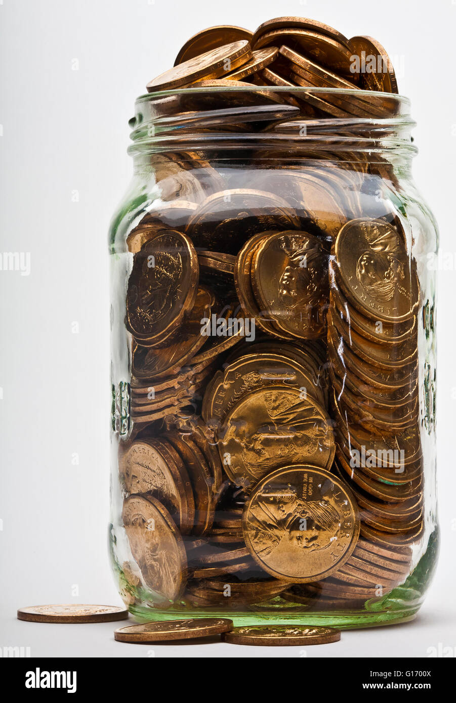 full overflowing jar of US dollar gold coins Stock Photo
