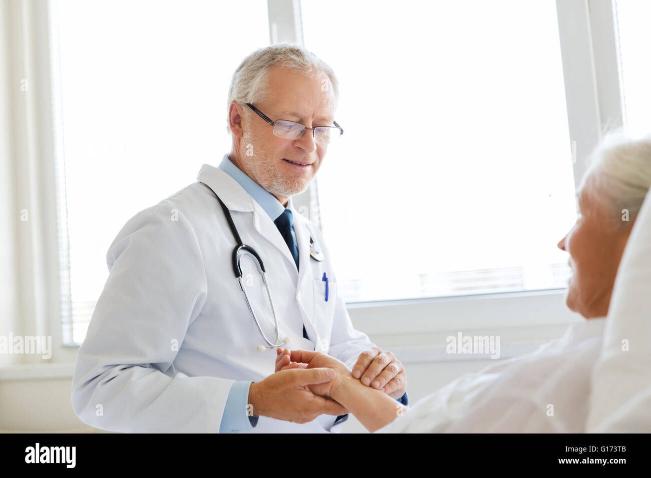 doctor checking senior woman pulse at hospital Stock Photo - Alamy