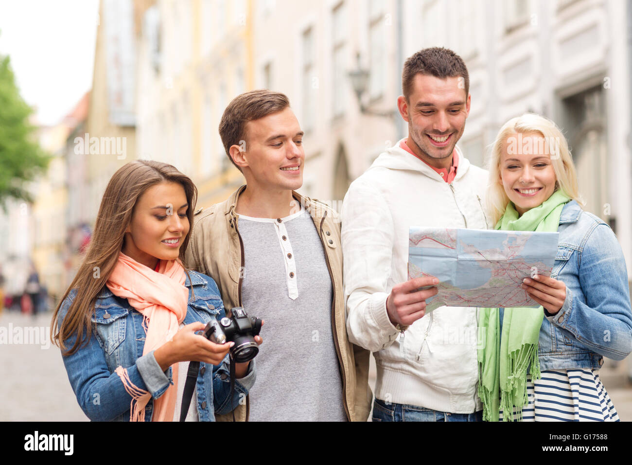 group of smiling friends with map and photocamera Stock Photo - Alamy