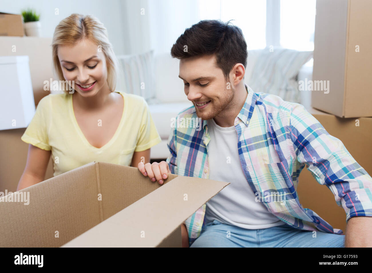 smiling couple with big boxes moving to new home Stock Photo - Alamy